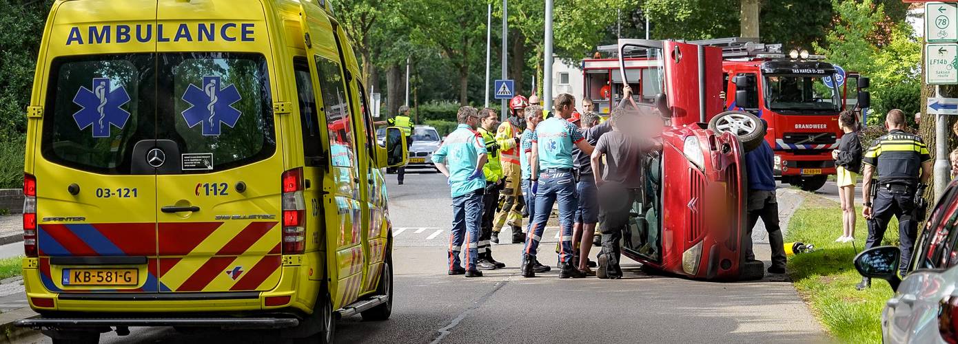 Automobiliste botst tegen vluchtheuvel en kantelt met auto