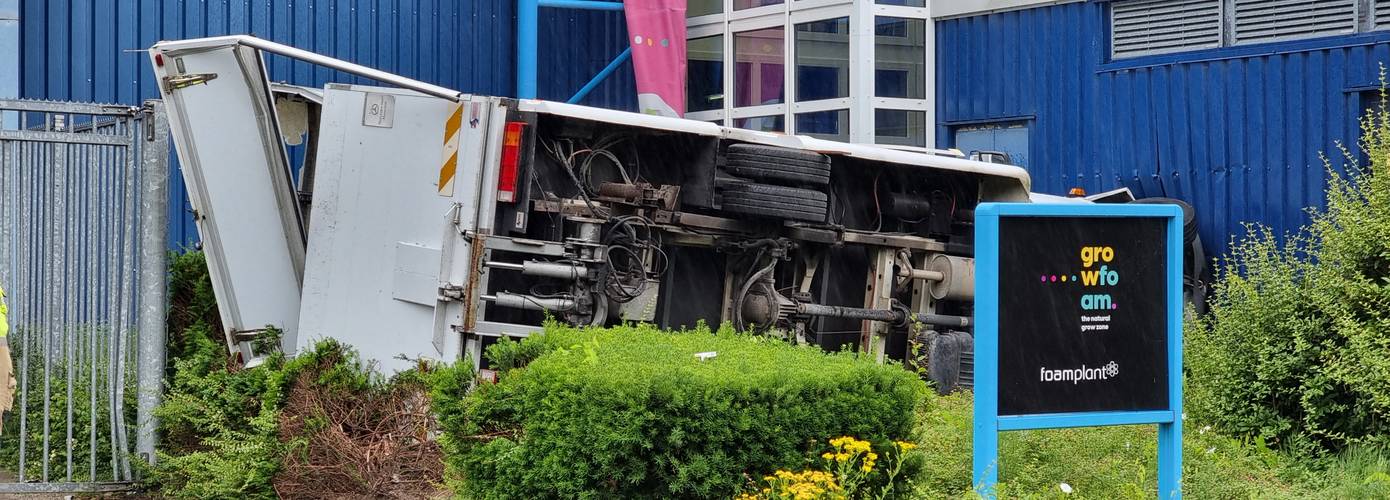 Bestelbus gekanteld en komt terecht in struiken voor bedrijfspand in Groningen