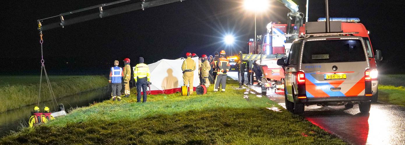 Auto op de kop in de sloot bij Midwolda door gladheid; één persoon zwaargewond