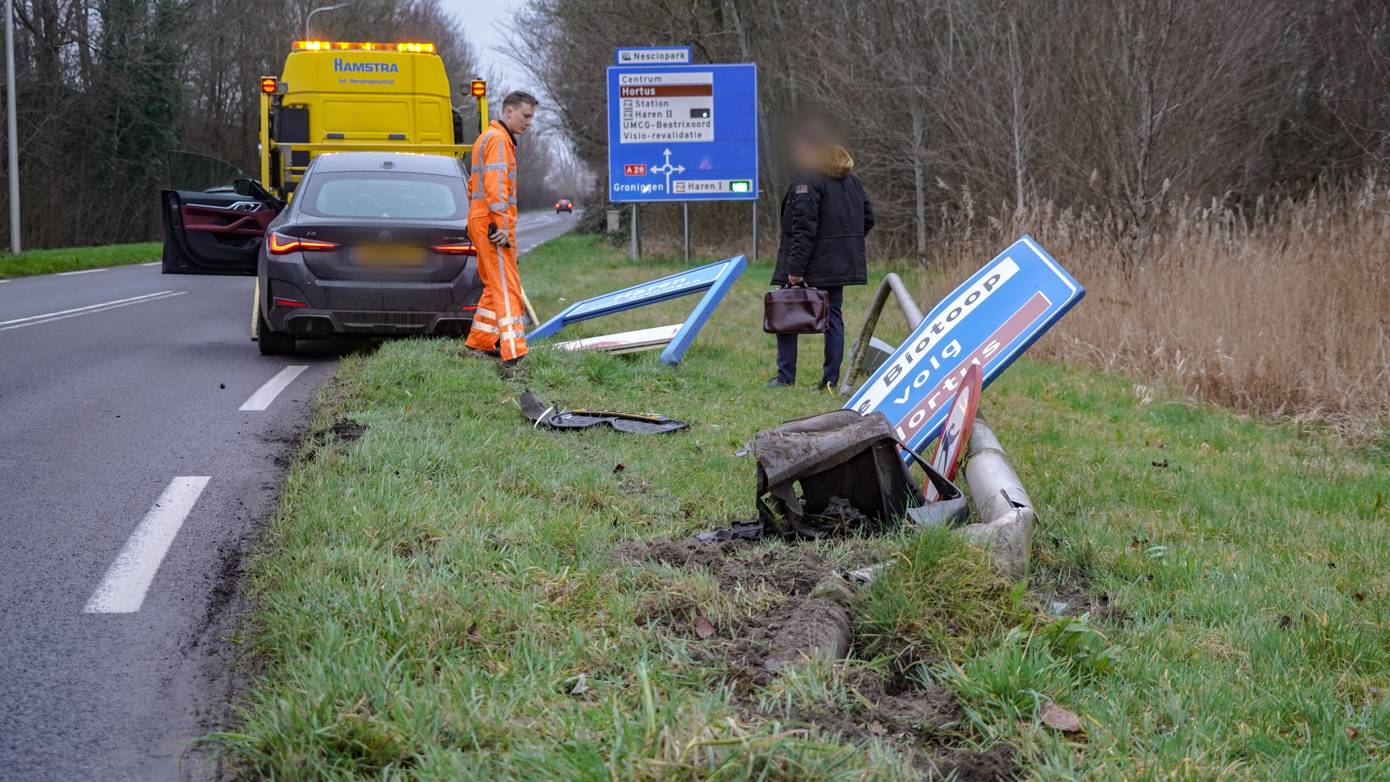 Automobilist ramt lantaarnpaal en plaatsnaambord, forse schade