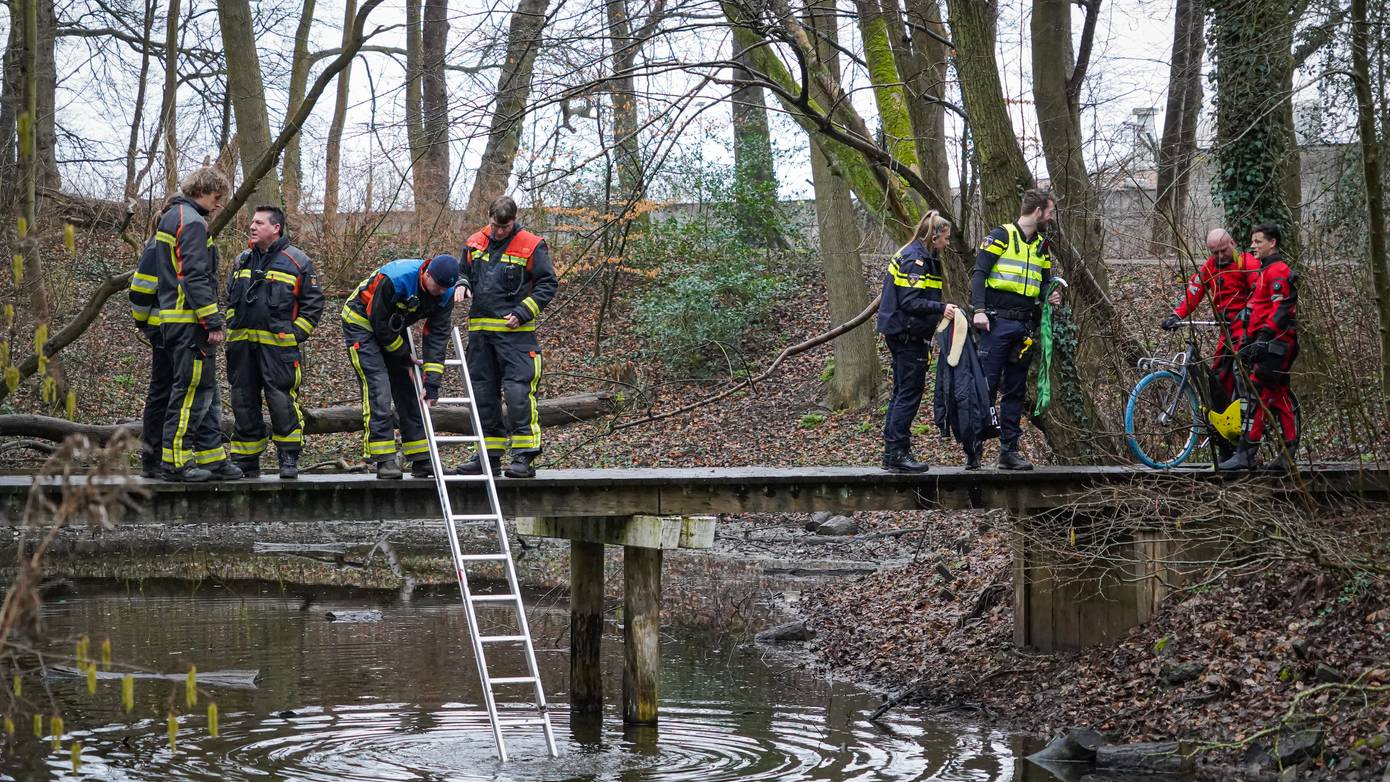 Telefonerende fietser rijdt vanaf brug het water in