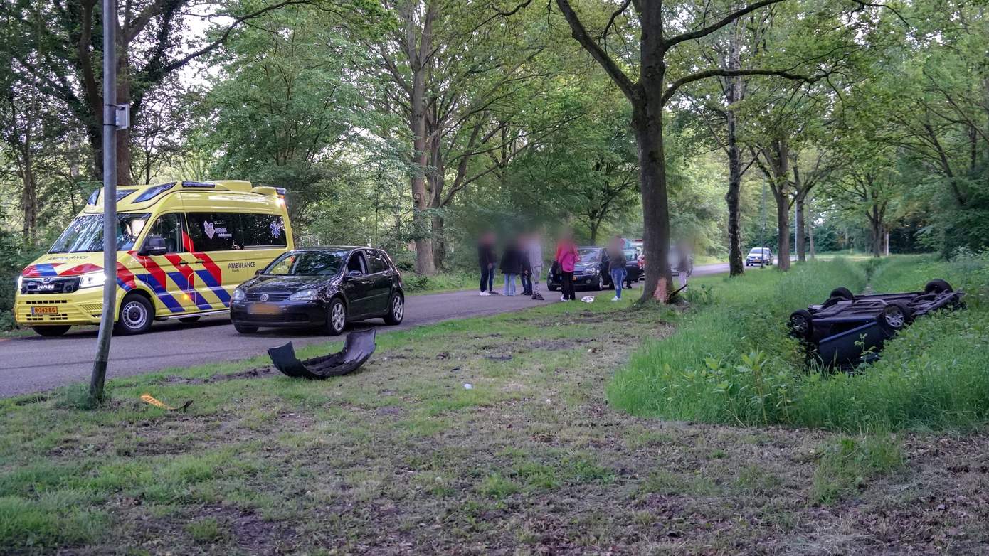 Automobilist raakt lantaarnpaal, boom en vliegt over de kop