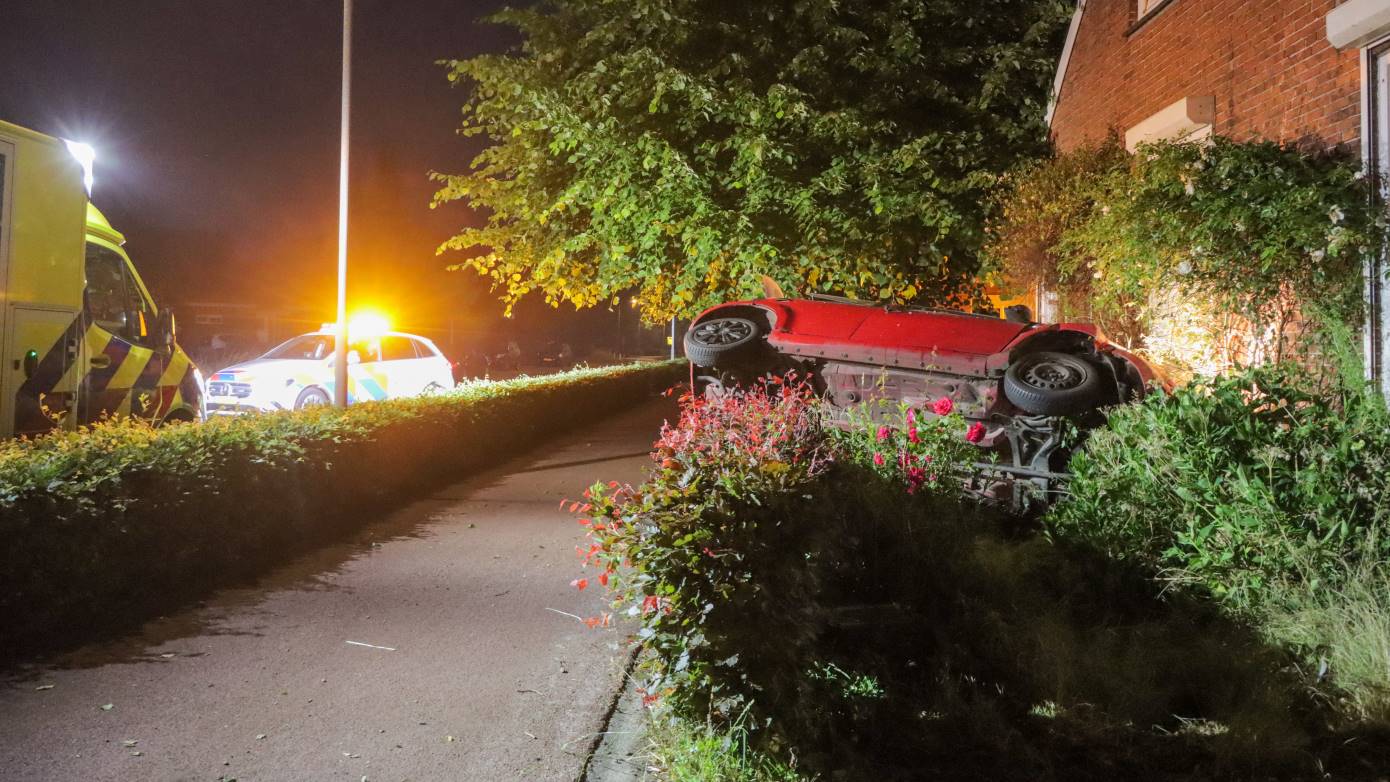 Automobilist slaat over de kop en belandt in voortuin van woning