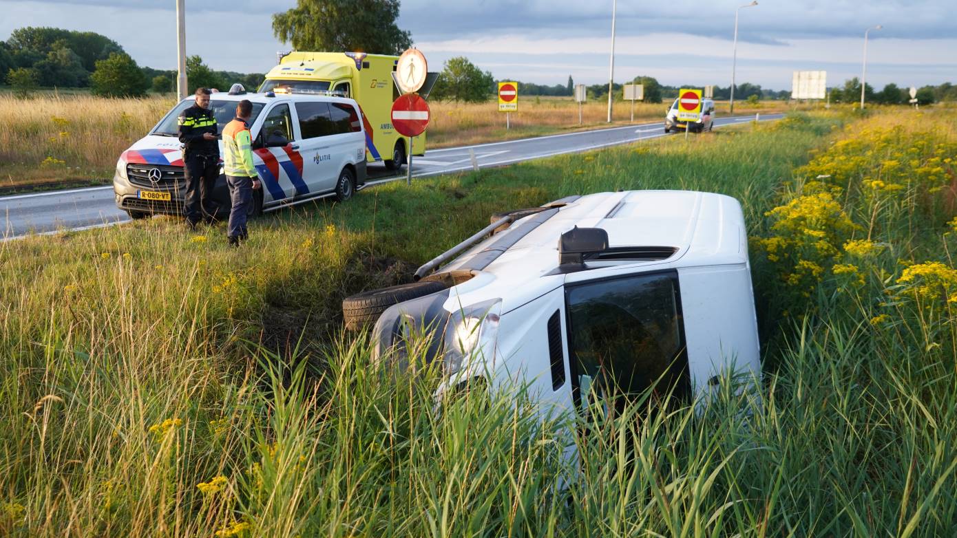 Bestelbus belandt op de zijkant in de berm onderaan afrit A28