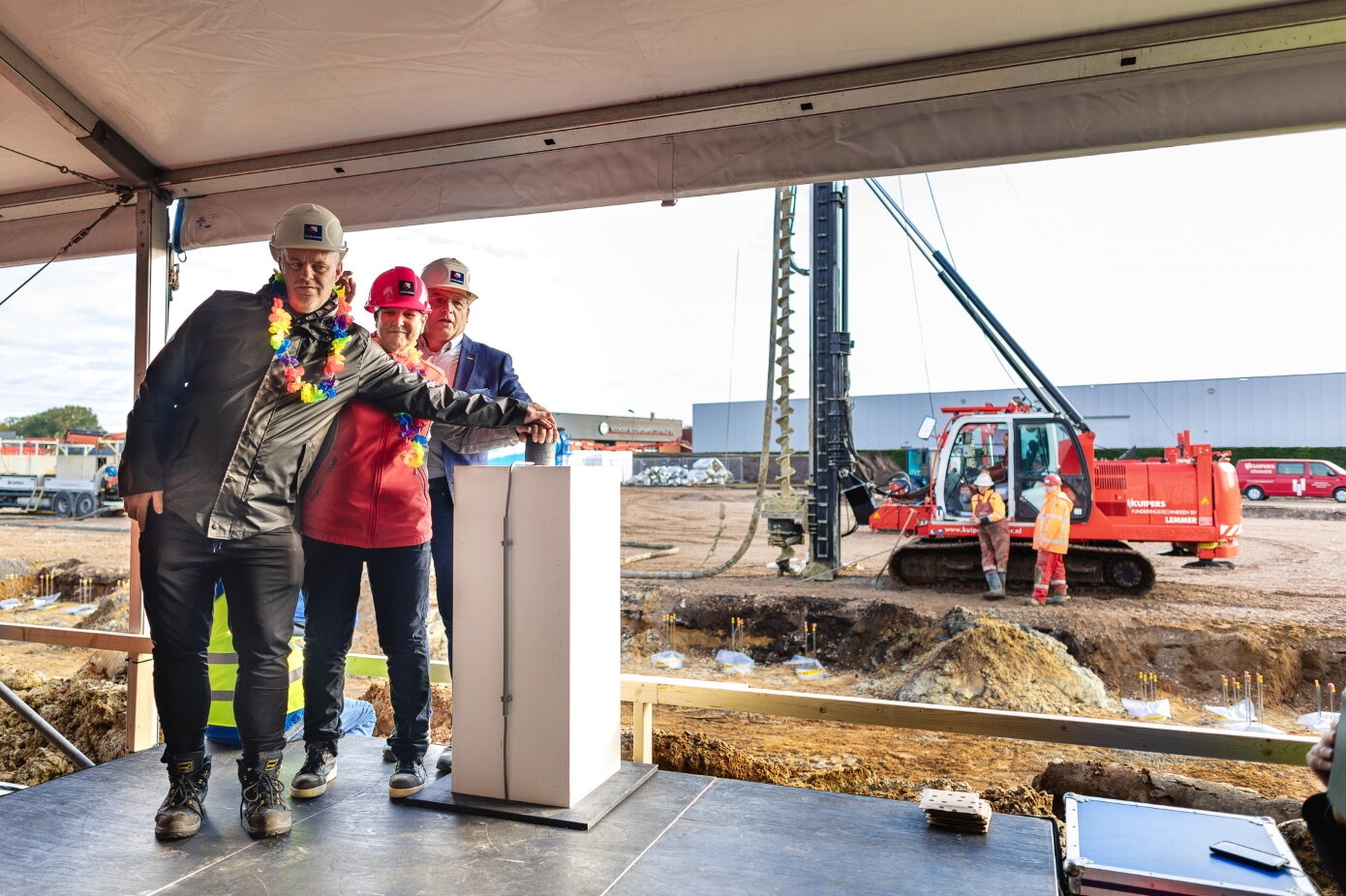 Twee medewerkers van Novatec geven samen met wethouder Nederveen het startsein voor de bouw van een nieuw pand